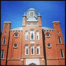 a large red brick building with a green dome on top