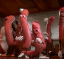 a group of sausages with faces and arms are dancing together .