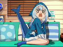 a girl in a shark costume sits on a blue couch