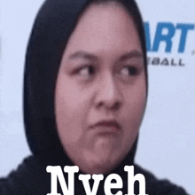 a woman wearing a hijab is making a funny face and the words nyeh are visible