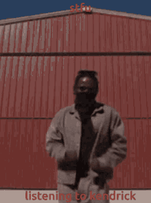 a man dancing in front of a red wall with the words listening to kendrick