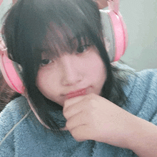 a girl wearing pink headphones and a blue blanket