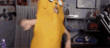 a person in a yellow costume is dancing in front of a microphone .