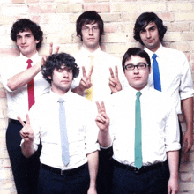 a group of men in white shirts and ties pose for a picture