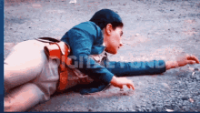 a man in a blue jacket is laying on the ground in front of a sign that says right turn