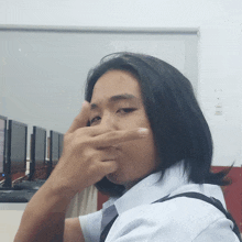 a man covering his nose with his hand in front of computer monitors