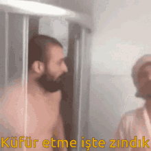 a shirtless man standing in a shower with the words kufur etme iste zindik written below him