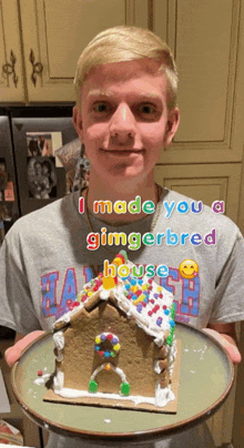 a young man is holding a gingerbread house on a plate with the caption " i made you a gingerbread house "