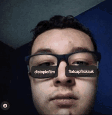 a man wearing glasses with the words distopiafilm and flatcap flicksuk written on them