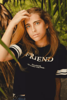 a girl wearing a black shirt that says friend