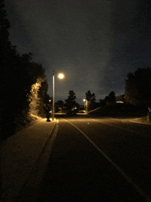 a dark street with a street light on the right side