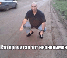 a man squatting on the side of a road with a car in the background and a caption in russian