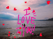 a couple swimming in the ocean with the words i love you written in pink