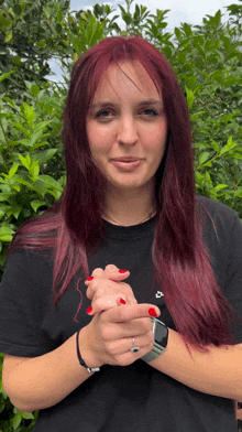 a woman with red hair is wearing a black shirt with a nike logo on it