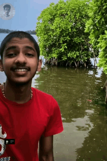 a man wearing a red shirt that says ' shiva ' on it