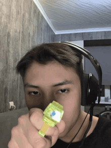 a young man wearing headphones is holding a toy in front of his face