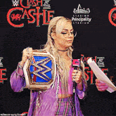 a woman is holding a wrestling championship belt and speaking into a microphone in front of a sign that says principality stadium