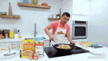 a man is preparing food in a kitchen with a bag of good life egg noodles in the background .