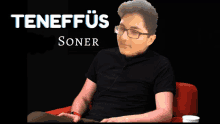 a man wearing glasses is sitting in a chair with the name teneftus soner written above him