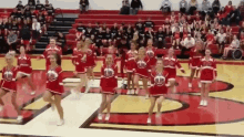 a group of cheerleaders are performing in front of a crowd wearing red uniforms with the letters hs on them