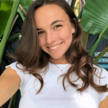 a woman is smiling in front of a sign that says tropical drink