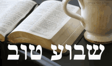 an open bible sits on a table next to a pitcher