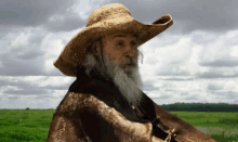 a man with a beard wearing a straw hat and a poncho