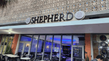 the outside of a restaurant called shepherd with tables and chairs