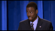 a man in a suit and tie with an american flag on his chest