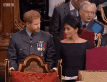 a man in a military uniform sits next to a woman in a black dress in front of a bbc logo