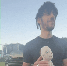 a man with dreadlocks is holding a stuffed animal