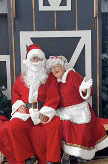 a man and a woman dressed as santa and mrs claus