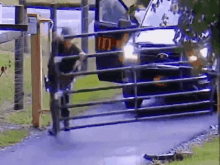 a man is pushing a fence to stop a truck from entering a driveway .