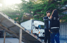 a man and a woman are standing next to each other with the man wearing a black shirt that says police on it