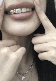 a close up of a woman 's teeth with a star shaped grill