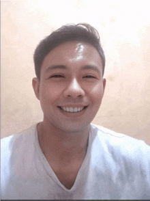 a man wearing a white shirt is smiling with his mouth open