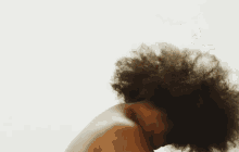 a close up of a person 's back with their hair blowing in the wind