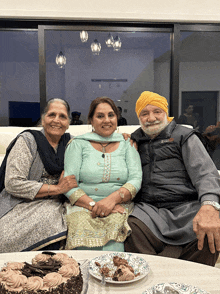 a man wearing a jacket that says ' columbia ' on it sits with two women