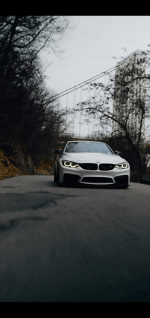 a white bmw is driving down a road