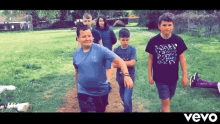 a group of young boys are walking down a path in a field .