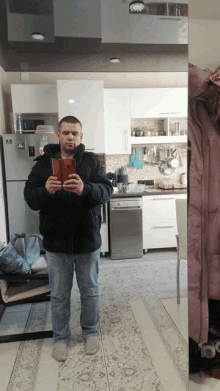 a man taking a picture of himself in front of a mirror in a kitchen