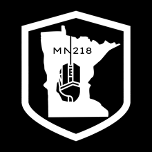 a white shield with a map of minnesota and the number 218 on it