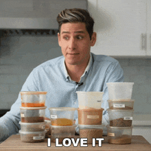 a man sitting at a table with containers of spices and the words " i love it " below him