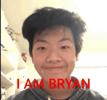 a young man is smiling in front of a sign that says i am bryan on it .