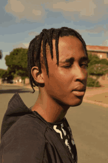 a young man wearing a black hoodie and a black and white shirt