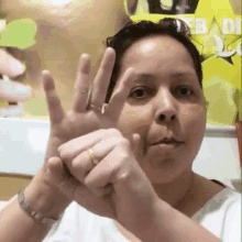 a woman with a ring on her finger is making a gesture with her hands .