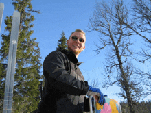 a man wearing a black jacket and blue gloves is holding a ski