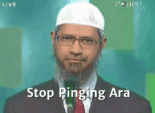 a man with a beard and glasses is talking into a microphone and says stop pinging ara