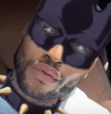 a man with a beard is wearing a purple batman mask