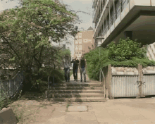 a group of people are walking down stairs in front of a building with a sign that says ' a ' on it